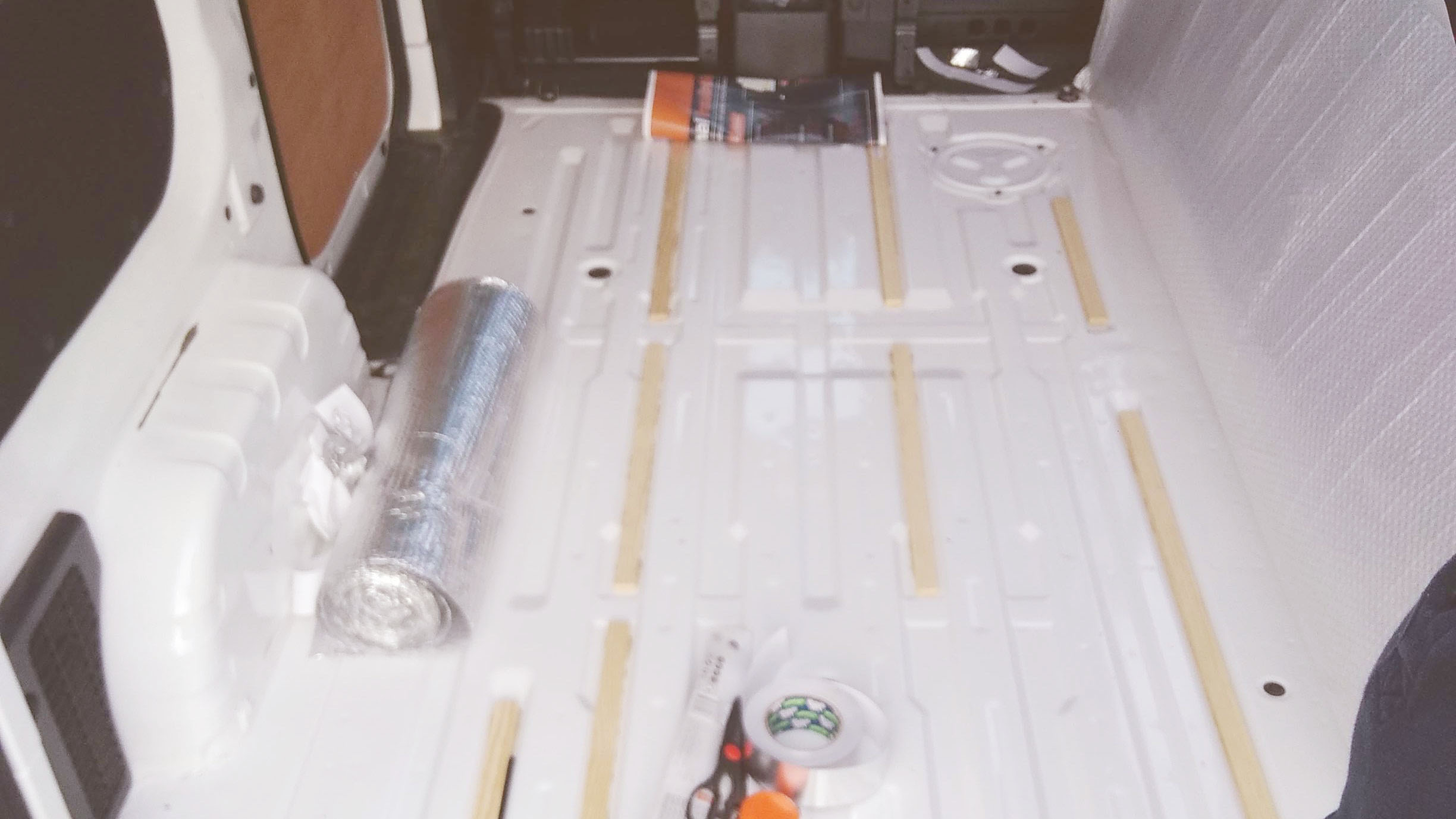 Van floor with wooden stripped glued in between the ribs