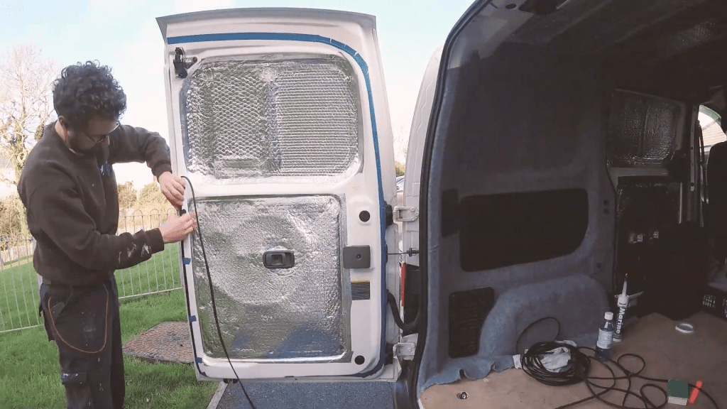 Taping the rubber to the van door with masking tape