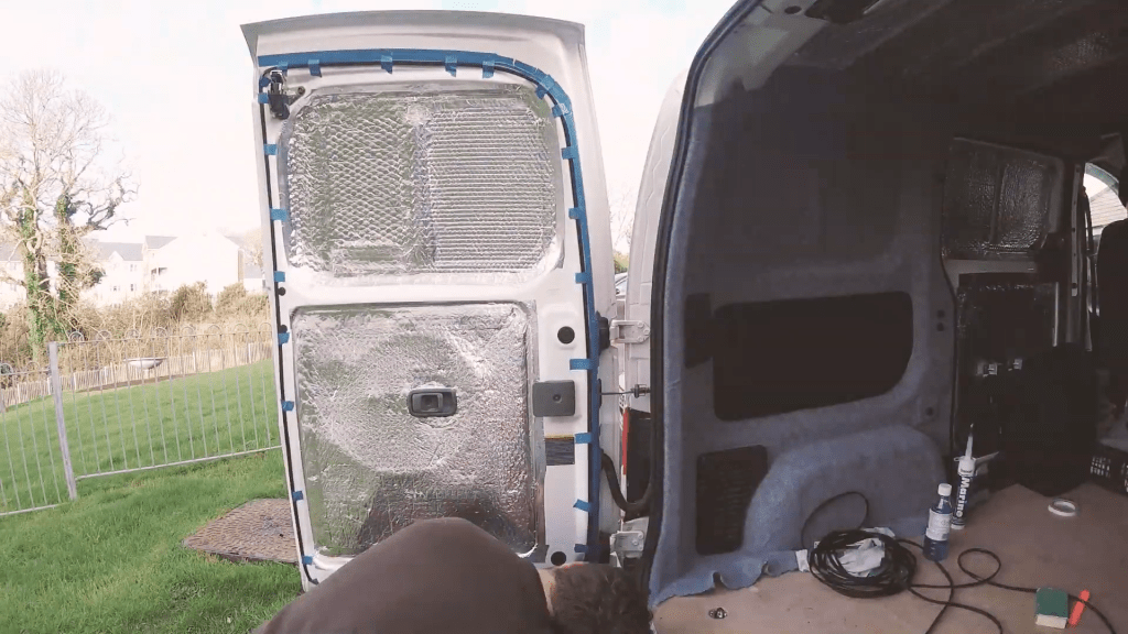 The rubber U-channel taped to the van door