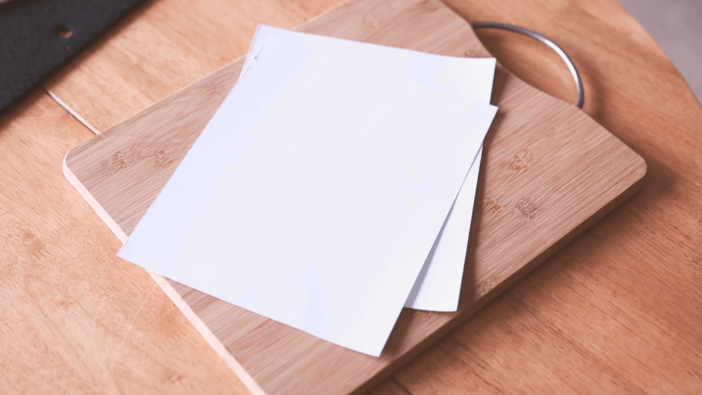 Two identical pieces of card on a cutting board
