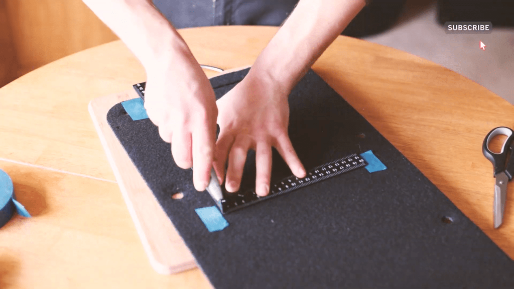 Cutting into the door panel card with a Stanley knife and right angle ruler