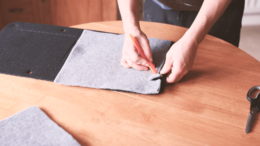 Pushing the carpet pocket through the slots in the door card