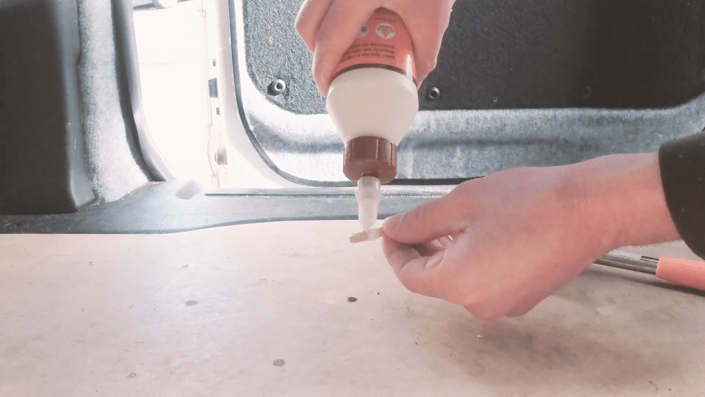 Spreading wood glue on wooden dowels