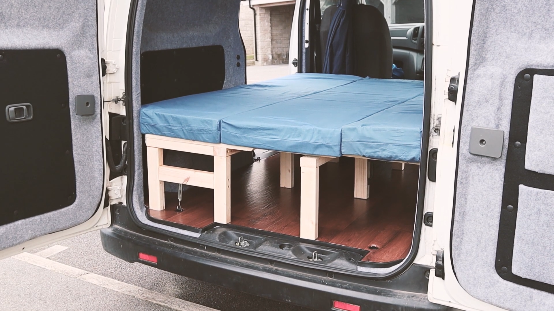 The finished bed laid out in the van with mattresses on top