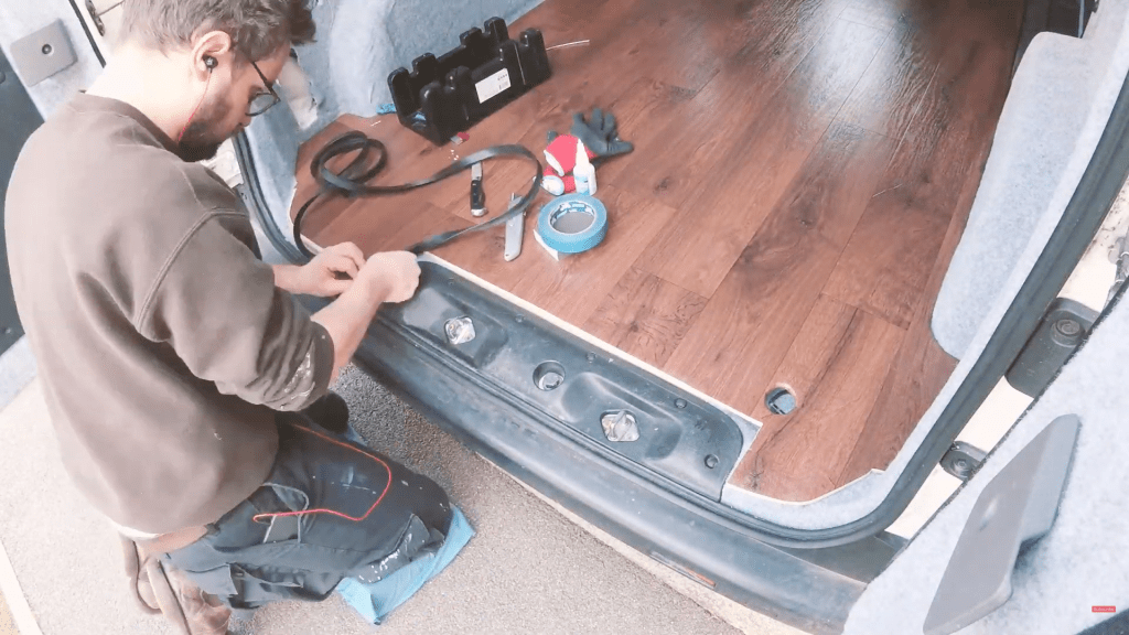 Gluing black rubber L-section to the van floor edge