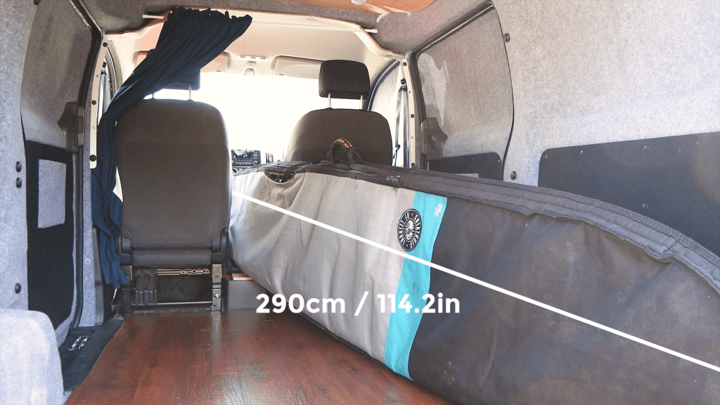 9' 5" surfboard between the seats of a Nissan NV200