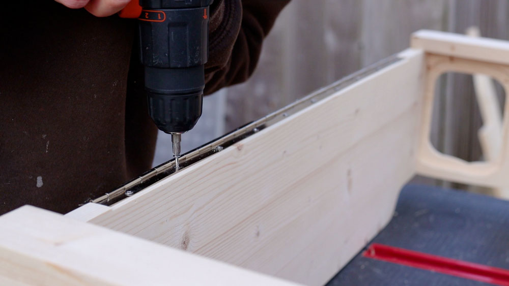Screwing the continuous piano hinge into the recess