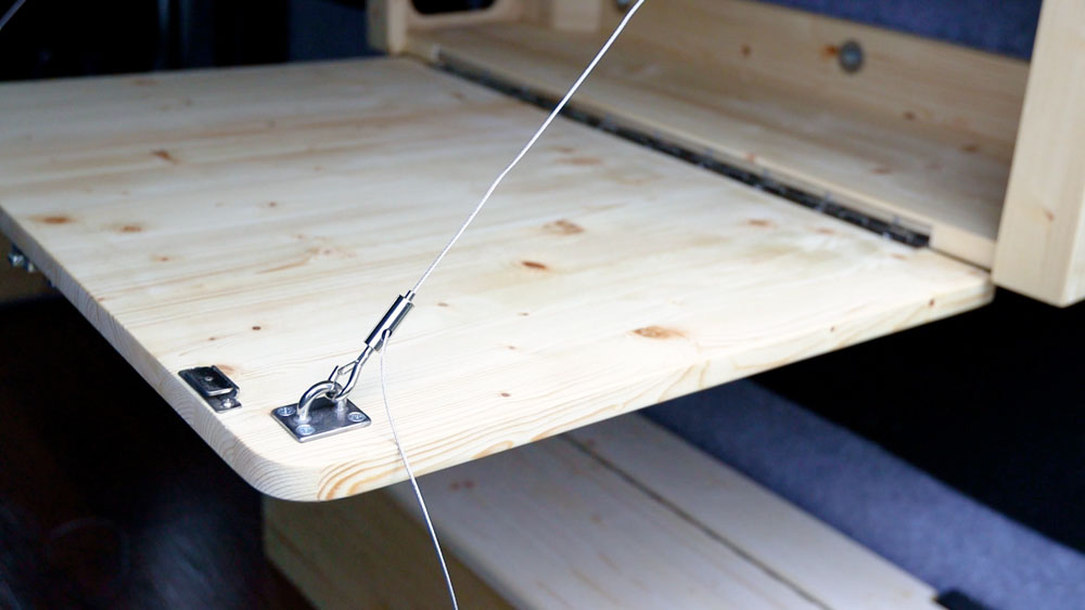 Metal hook clipped onto a van table eye plate