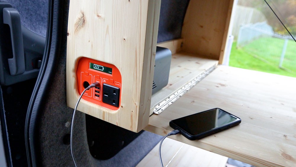 A portable battery pack showing from a side opening in a van table