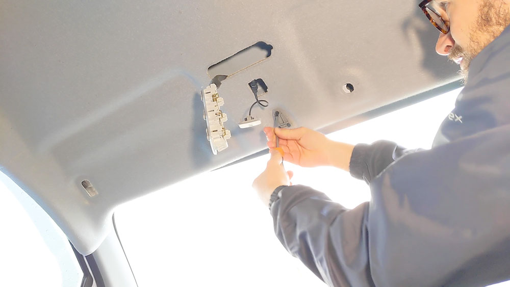 Unscrewing the wing mirror plate to release the headliner