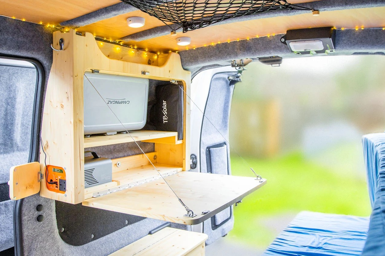 Fold-down table with built-in battery and storage, in my Nissan NV200 tiny camper conversion