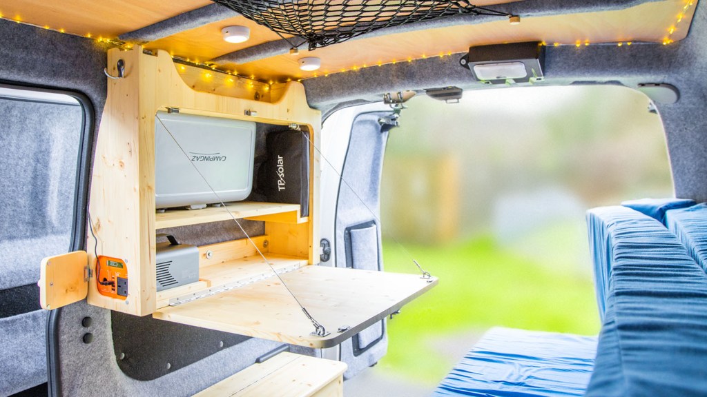 Fold-down table with built-in battery and storage, in my Nissan NV200 tiny camper conversion