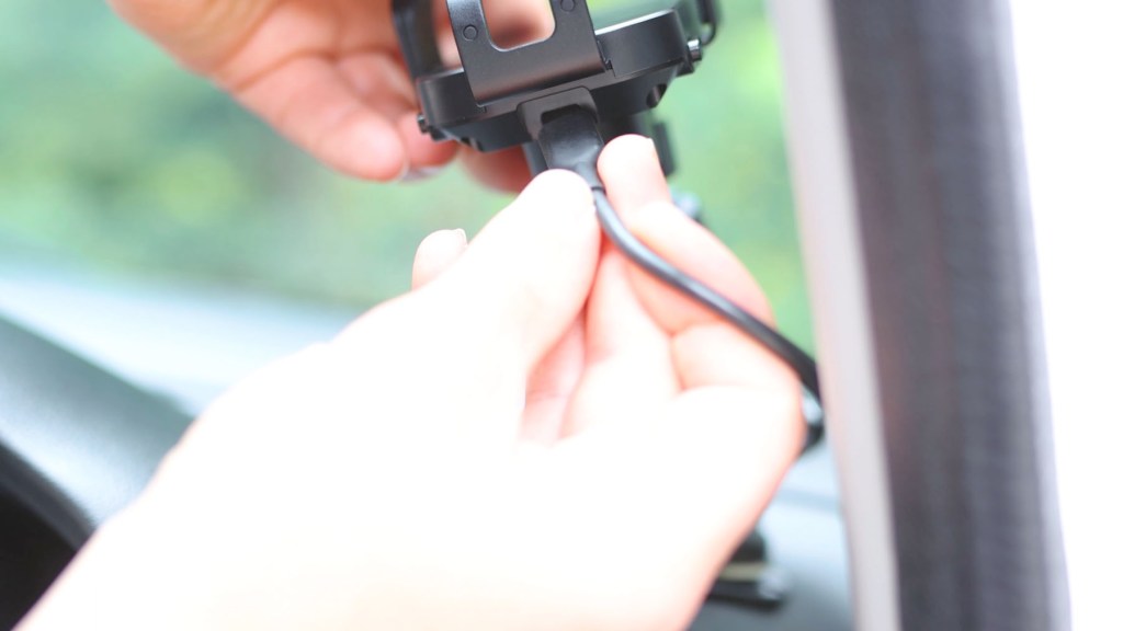 Plugging a USB-C power cable into the wireless car phone holder