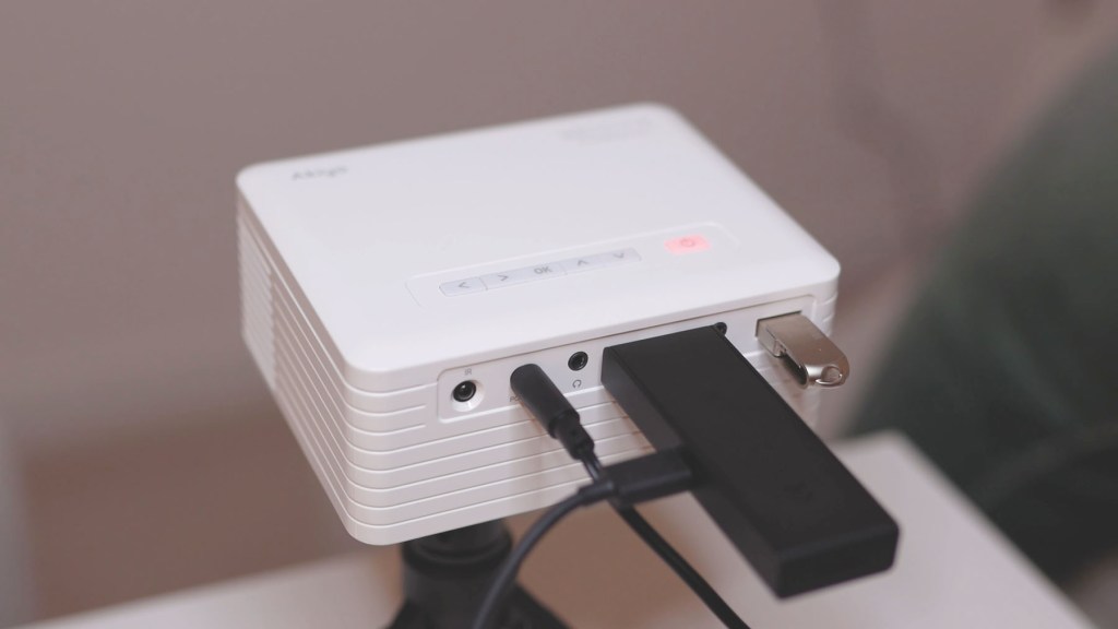 Amazon Fire TV stick inserted in the Akiyo O1 tiny projector