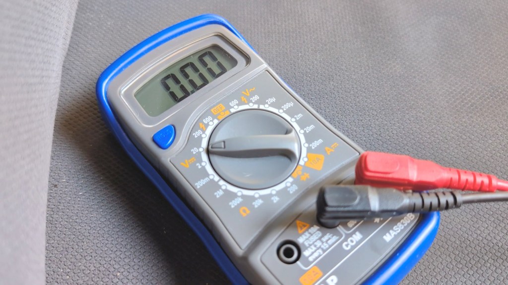 Digital multimeter set to 20v in the DC range, for a car battery